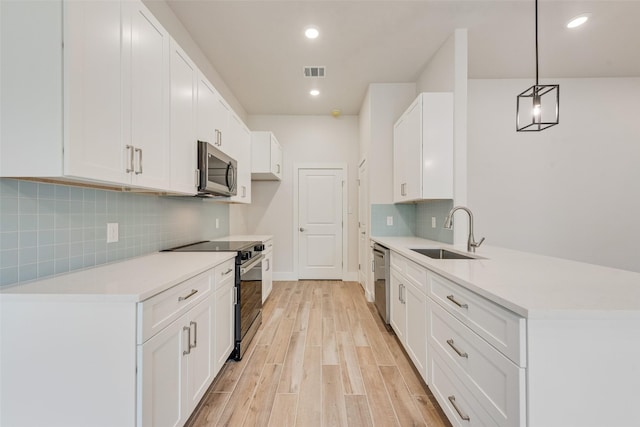 137 Willow Ln, Roanoke, TX 76262 - kitchen with stainless steel appliances, a sink, a peninsula, backsplash, and light countertops