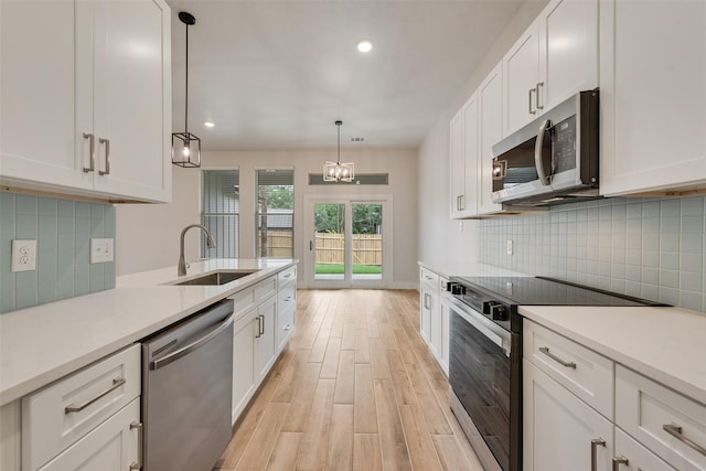 137 Willow Ln, Roanoke, TX 76262 - kitchen with stainless steel appliances, a sink, light wood-type flooring, white cabinetry, and recessed lighting