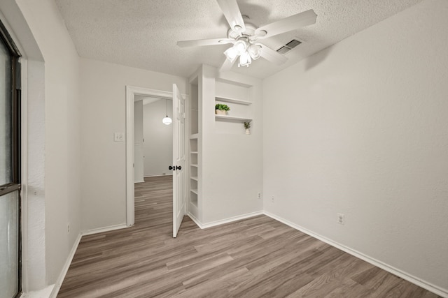 2911 Post Oak Dr, Euless, TX 76039 - empty room with a textured ceiling, light wood finished floors, ceiling fan, and baseboards