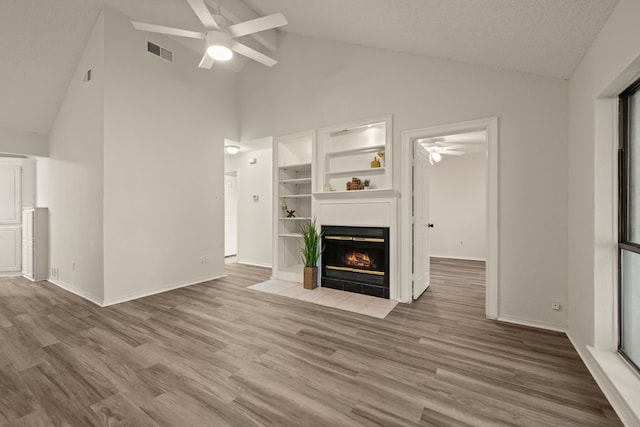 2911 Post Oak Dr, Euless, TX 76039 - unfurnished living room with a ceiling fan, high vaulted ceiling, a fireplace with flush hearth, wood finished floors, and baseboards