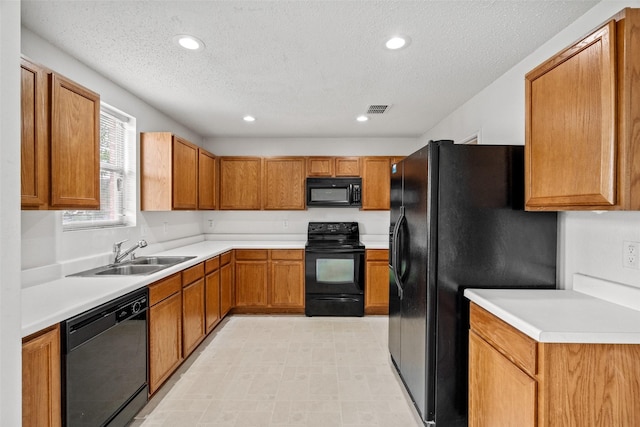 16616 Jasmine Springs Dr, Fort Worth, TX 76247 - kitchen featuring black appliances, a sink, brown cabinetry, a textured ceiling, and light countertops