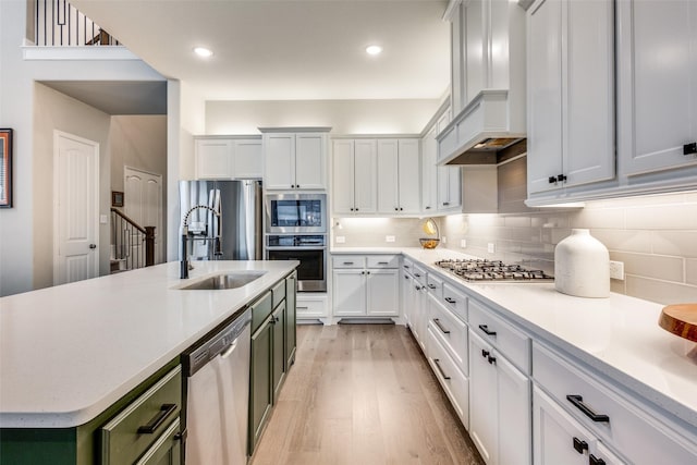 1421 Benavites Dr, Little Elm, TX 75068 - kitchen with stainless steel appliances, premium range hood, light countertops, a sink, and light wood-type flooring