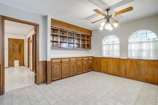 502 Roaring Springs Dr, Joshua, TX 76058 - unfurnished dining area with a ceiling fan, wainscoting, light floors, and wooden walls