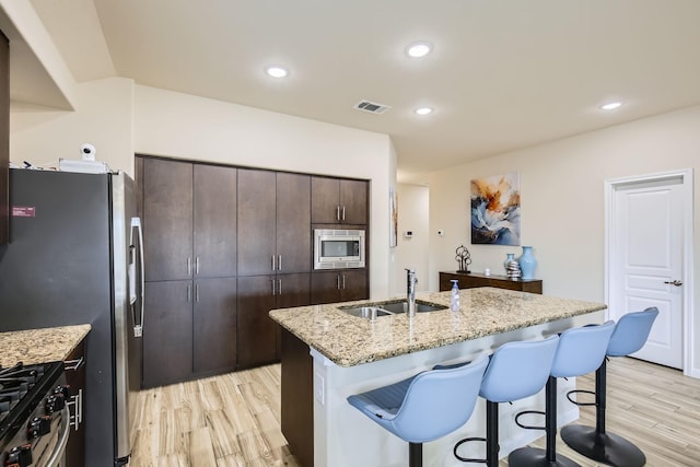 3446 Kirby Ln, Forney, TX 75126 - kitchen with a sink, stainless steel appliances, light wood-type flooring, a kitchen breakfast bar, and dark brown cabinets