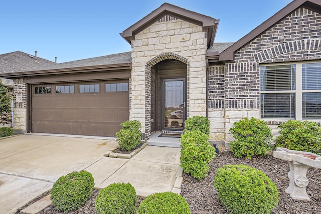 3446 Kirby Ln, Forney, TX 75126 - property entrance featuring a garage, driveway, a shingled roof, and stone siding