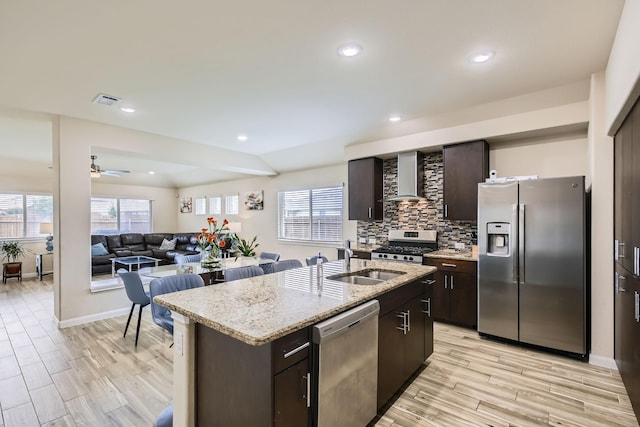 3446 Kirby Ln, Forney, TX 75126 - kitchen featuring stainless steel appliances, wall chimney exhaust hood, dark brown cabinets, a sink, and decorative backsplash