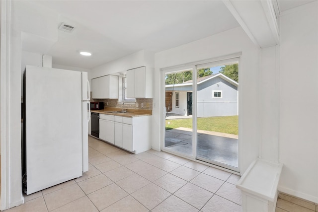 2425 Misty Ln, Carrollton, TX 75006 - kitchen featuring black appliances, light countertops, a sink, white cabinetry, and light tile patterned floors
