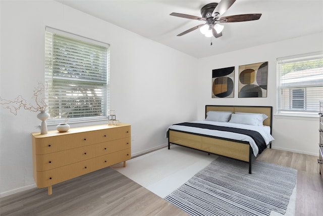 2425 Misty Ln, Carrollton, TX 75006 - bedroom with light wood-style flooring, a ceiling fan, and baseboards