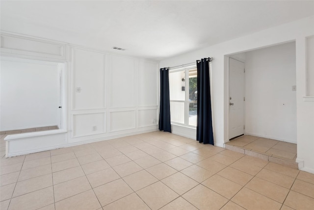 2425 Misty Ln, Carrollton, TX 75006 - empty room with a decorative wall and light tile patterned floors