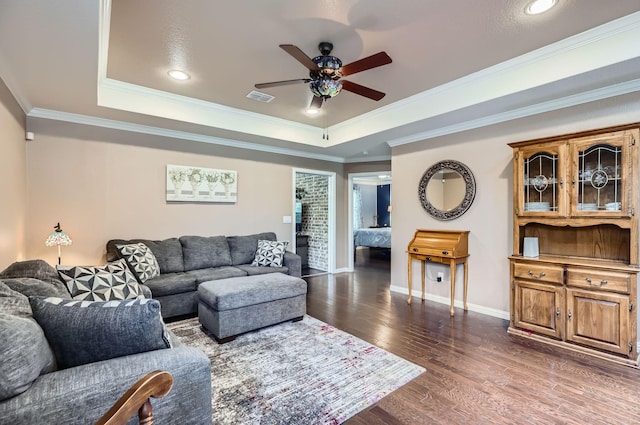 8745 Twin Pines Ln, Frisco, TX 75036 - living room featuring a tray ceiling, ceiling fan, dark wood-style floors, ornamental molding, and baseboards