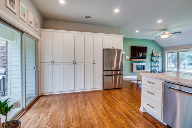 4017 Piedmont Rd, Fort Worth, TX 76116 - kitchen with stainless steel appliances, white cabinets, baseboards, ceiling fan, and light wood-type flooring