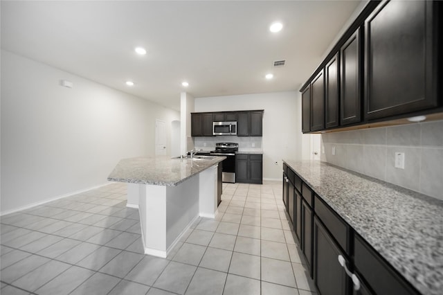 708 Rustic Meadows Trl, Princeton, TX 75407 - kitchen featuring appliances with stainless steel finishes, light tile patterned floors, tasteful backsplash, light stone counters, and recessed lighting