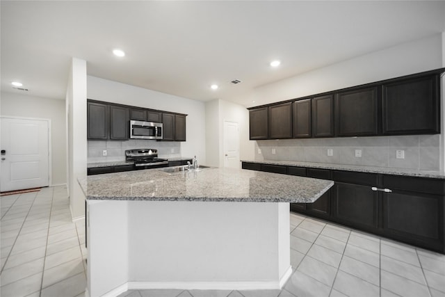 708 Rustic Meadows Trl, Princeton, TX 75407 - kitchen with stainless steel appliances, tasteful backsplash, light stone counters, light tile patterned flooring, and recessed lighting