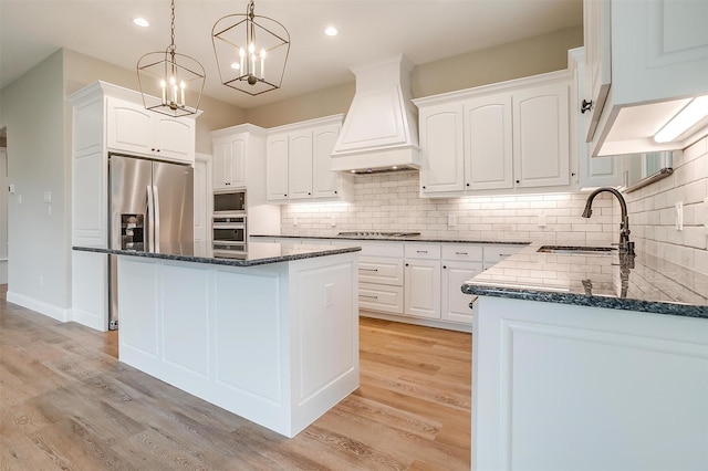 8732 Fullerton Dr, Cleburne, TX 76033 - kitchen with premium range hood, stainless steel appliances, a sink, dark stone counters, and recessed lighting