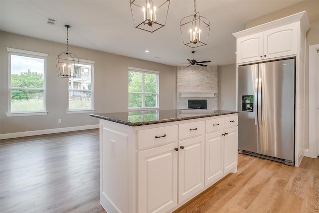 8732 Fullerton Dr, Cleburne, TX 76033 - kitchen featuring stainless steel refrigerator with ice dispenser, a chandelier, light wood-style flooring, a fireplace, and recessed lighting