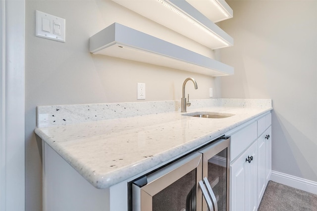 8732 Fullerton Dr, Cleburne, TX 76033 - kitchen featuring open shelves, a sink, light stone countertops, white cabinetry, and baseboards