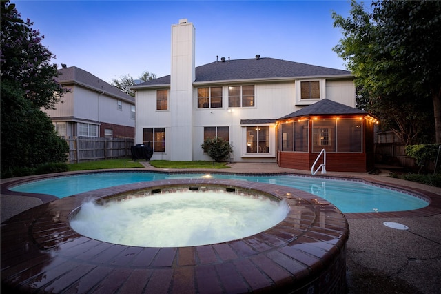 7705 Marble Canyon Ct, Fort Worth, TX 76137 - pool at dusk featuring a sunroom, a pool with connected hot tub, and area for grilling