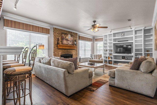7705 Marble Canyon Ct, Fort Worth, TX 76137 - living room featuring a fireplace, rail lighting, a ceiling fan, dark wood-style floors, and ornamental molding