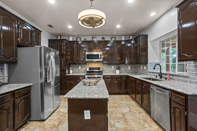 7705 Marble Canyon Ct, Fort Worth, TX 76137 - kitchen with stainless steel appliances, a sink, a kitchen island, dark brown cabinets, and backsplash