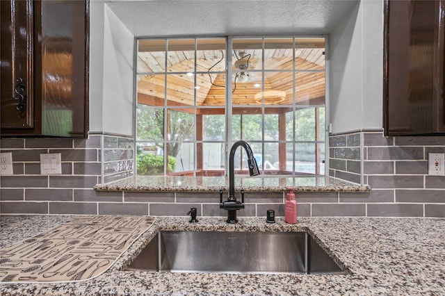 7705 Marble Canyon Ct, Fort Worth, TX 76137 - detailed view of dark brown cabinetry, a sink, and backsplash