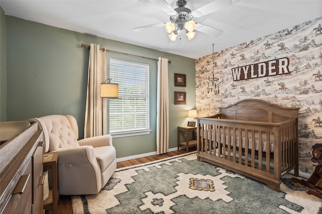7705 Marble Canyon Ct, Fort Worth, TX 76137 - bedroom with baseboards, wood finished floors, a nursery area, and a ceiling fan