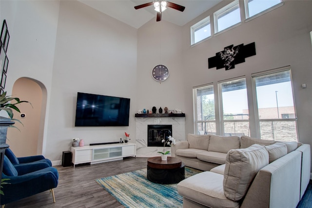 12990 Twelve Oaks Ave, Frisco, TX 75035 - living room featuring high vaulted ceiling, ceiling fan, a fireplace, dark wood-style floors, and baseboards