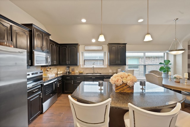 11913 Bellegrove Rd, Burleson, TX 76028 - kitchen with appliances with stainless steel finishes, wood finished floors, decorative backsplash, a center island, and a sink