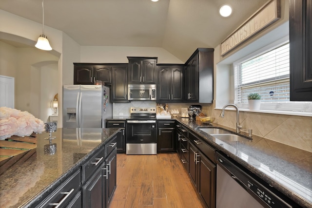 11913 Bellegrove Rd, Burleson, TX 76028 - kitchen with appliances with stainless steel finishes, a sink, arched walkways, dark stone countertops, and lofted ceiling