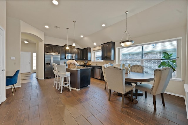 11913 Bellegrove Rd, Burleson, TX 76028 - dining room featuring vaulted ceiling, wood finished floors, baseboards, recessed lighting, and arched walkways