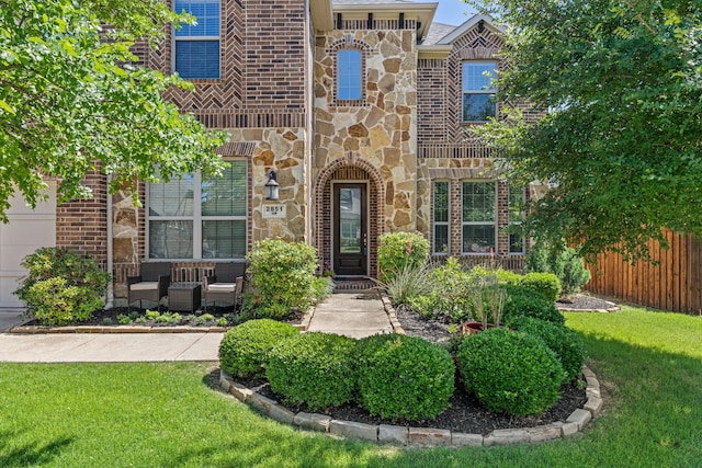 2851 Clearwater Dr, Prosper, TX 75078 - view of exterior entry featuring stone siding, an outdoor living space, and brick siding