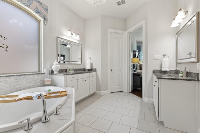 2851 Clearwater Dr, Prosper, TX 75078 - bathroom featuring two vanities, a bath, tile patterned flooring, baseboards, and a ceiling fan