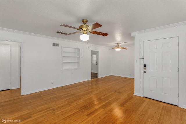 2932 W Cavett Dr, Shreveport, LA 71104 - unfurnished living room featuring built in features, ornamental molding, a ceiling fan, baseboards, and light wood-style floors