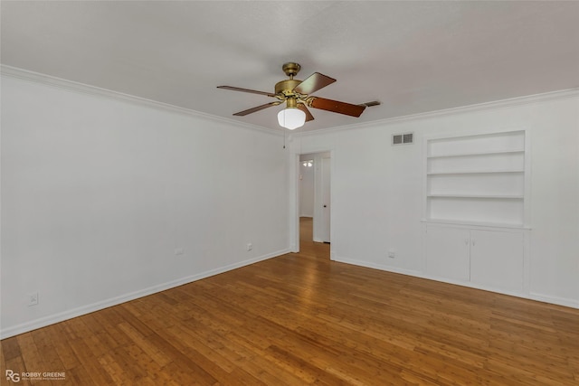 2932 W Cavett Dr, Shreveport, LA 71104 - empty room featuring a ceiling fan, built in features, ornamental molding, wood finished floors, and baseboards