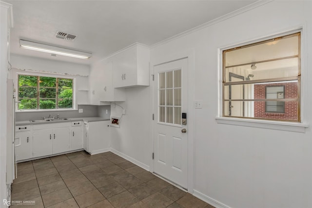 2932 W Cavett Dr, Shreveport, LA 71104 - kitchen featuring white cabinets, a sink, light countertops, baseboards, and crown molding