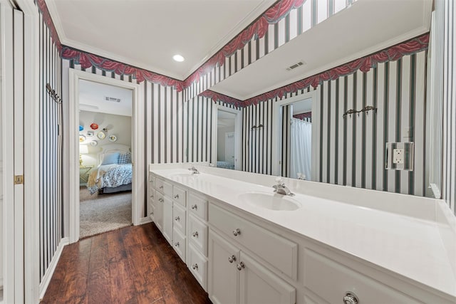 146 Shady Trl, Waco, TX 76657 - ensuite bathroom featuring wallpapered walls, crown molding, wood finished floors, double vanity, and baseboards