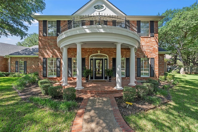 146 Shady Trl, Waco, TX 76657 - view of exterior entry featuring a balcony, a yard, brick siding, and covered porch