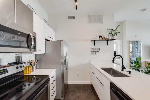 3025 Bryan St Unit 1F, Dallas, TX 75204 - kitchen featuring stainless steel appliances, a sink, light countertops, white cabinets, and baseboards