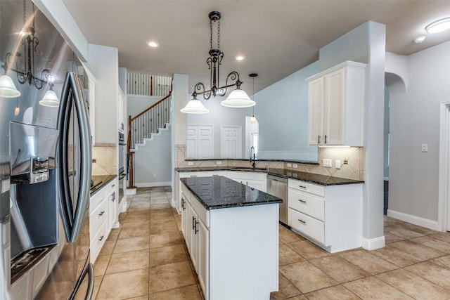 13274 Bayfield Dr, Frisco, TX 75033 - kitchen with appliances with stainless steel finishes, tasteful backsplash, a sink, white cabinets, and a kitchen island
