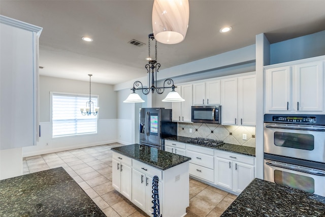 13274 Bayfield Dr, Frisco, TX 75033 - kitchen featuring appliances with stainless steel finishes, white cabinetry, wainscoting, a chandelier, and tasteful backsplash
