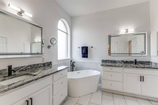 13274 Bayfield Dr, Frisco, TX 75033 - bathroom featuring two vanities, a soaking tub, and marble finish flooring