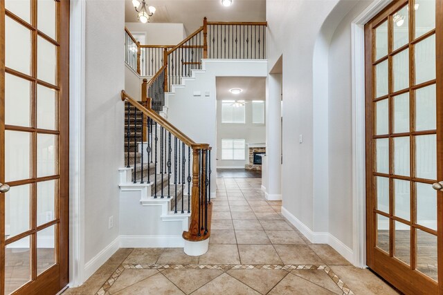 13274 Bayfield Dr, Frisco, TX 75033 - foyer entrance with light tile patterned floors, a high ceiling, ceiling fan, stairs, and arched walkways