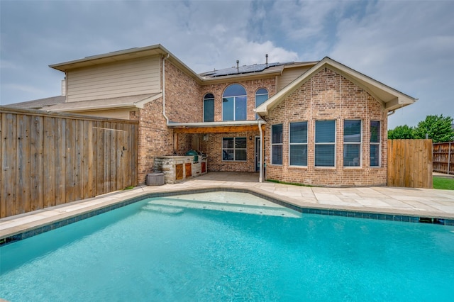 13274 Bayfield Dr, Frisco, TX 75033 - back of property with brick siding, solar panels, area for grilling, a patio area, and a fenced backyard