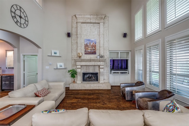 15630 Stonebridge Dr, Frisco, TX 75035 - living area featuring a high ceiling, plenty of natural light, wood finished floors, arched walkways, and a fireplace with raised hearth