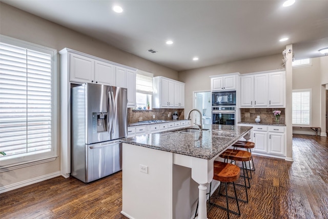 15630 Stonebridge Dr, Frisco, TX 75035 - kitchen featuring stainless steel appliances, white cabinets, backsplash, a sink, and baseboards