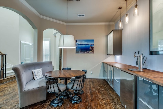 15630 Stonebridge Dr, Frisco, TX 75035 - dining area featuring dark wood-style flooring, arched walkways, ornamental molding, and baseboards