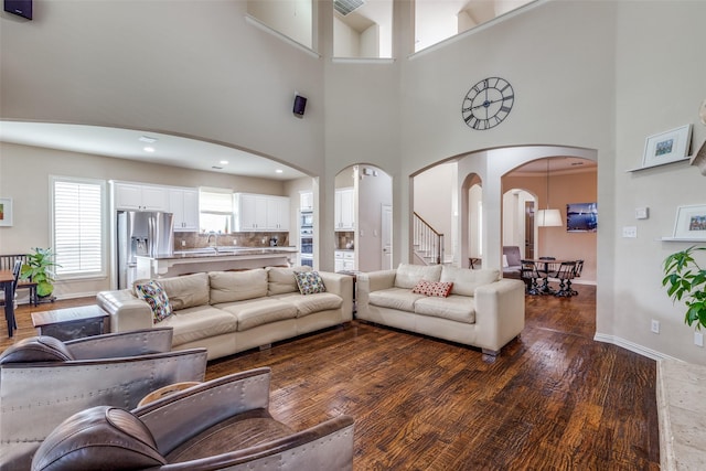 15630 Stonebridge Dr, Frisco, TX 75035 - living area featuring arched walkways, a towering ceiling, wood finished floors, and baseboards