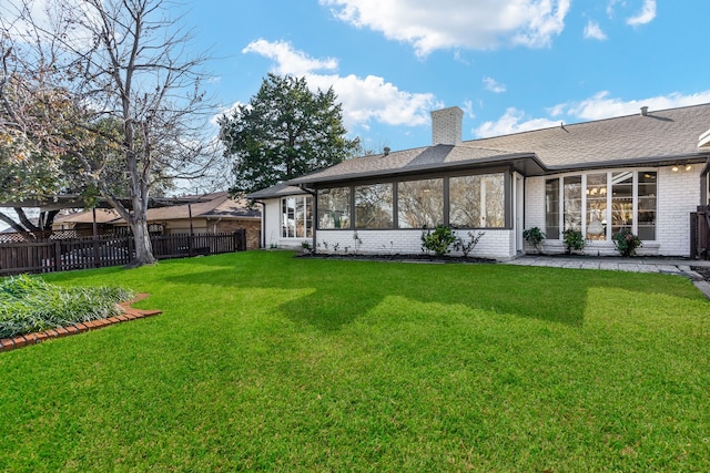 2005 Westshore Dr, Garland, TX 75043 - back of house featuring brick siding, a sunroom, a chimney, and roof with shingles