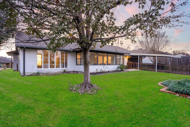 2005 Westshore Dr, Garland, TX 75043 - back of house at dusk with a sunroom and brick siding