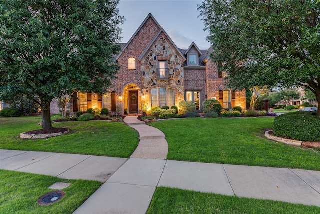 2758 Sharlis Dr, Frisco, TX 75036 - tudor house with a front yard, brick siding, and stone siding