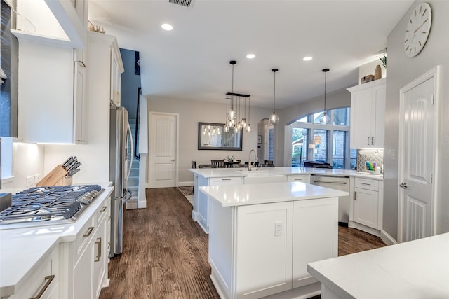 2758 Sharlis Dr, Frisco, TX 75036 - kitchen with a peninsula, a chandelier, stainless steel appliances, dark wood-style flooring, and recessed lighting
